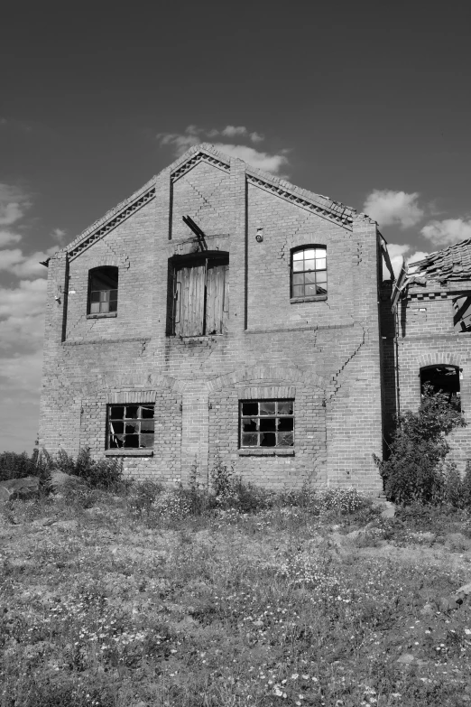 a brick building with an open window and a horse sticking out the window