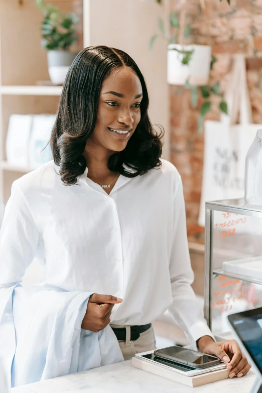 a woman smiling with a phone in her hand at a desk