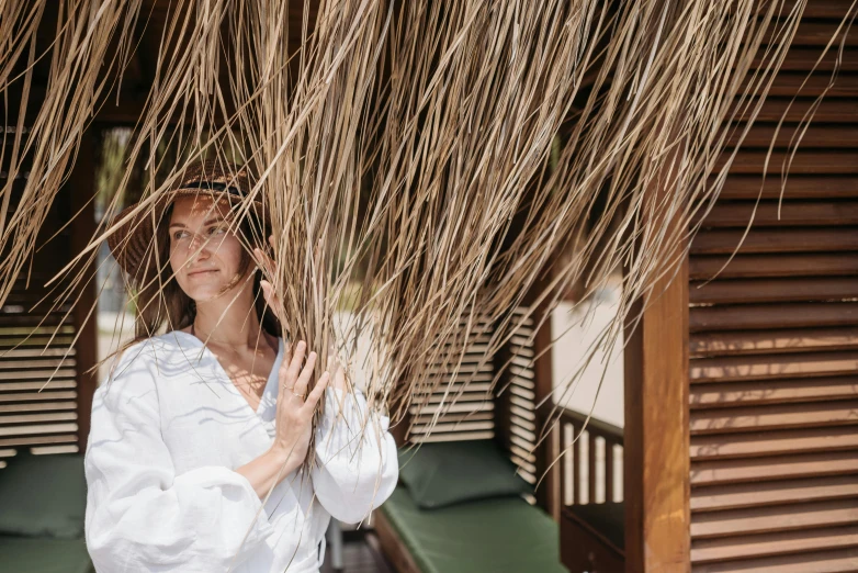 woman in white outfit standing under straw roof