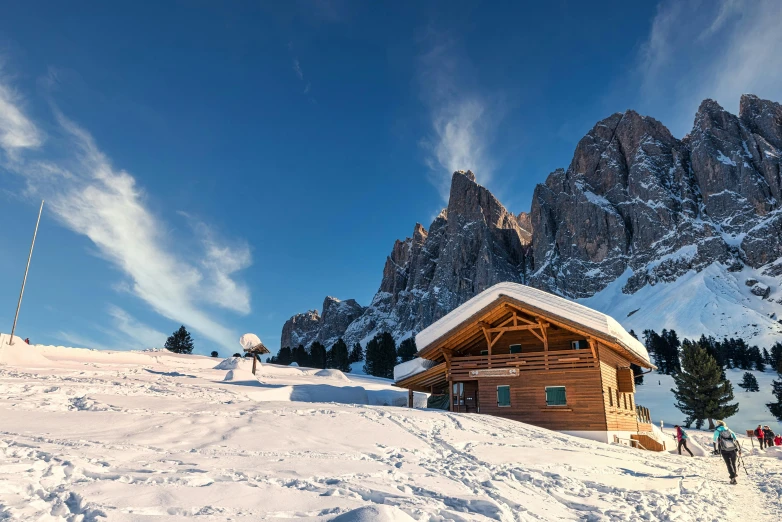 a mountain hut sits in the foreground and a couple others near by