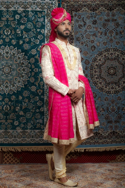 a man in a white and pink sherww with golden detailing