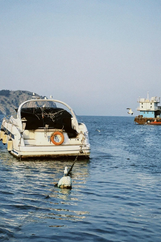 several boats traveling in the water off a beach