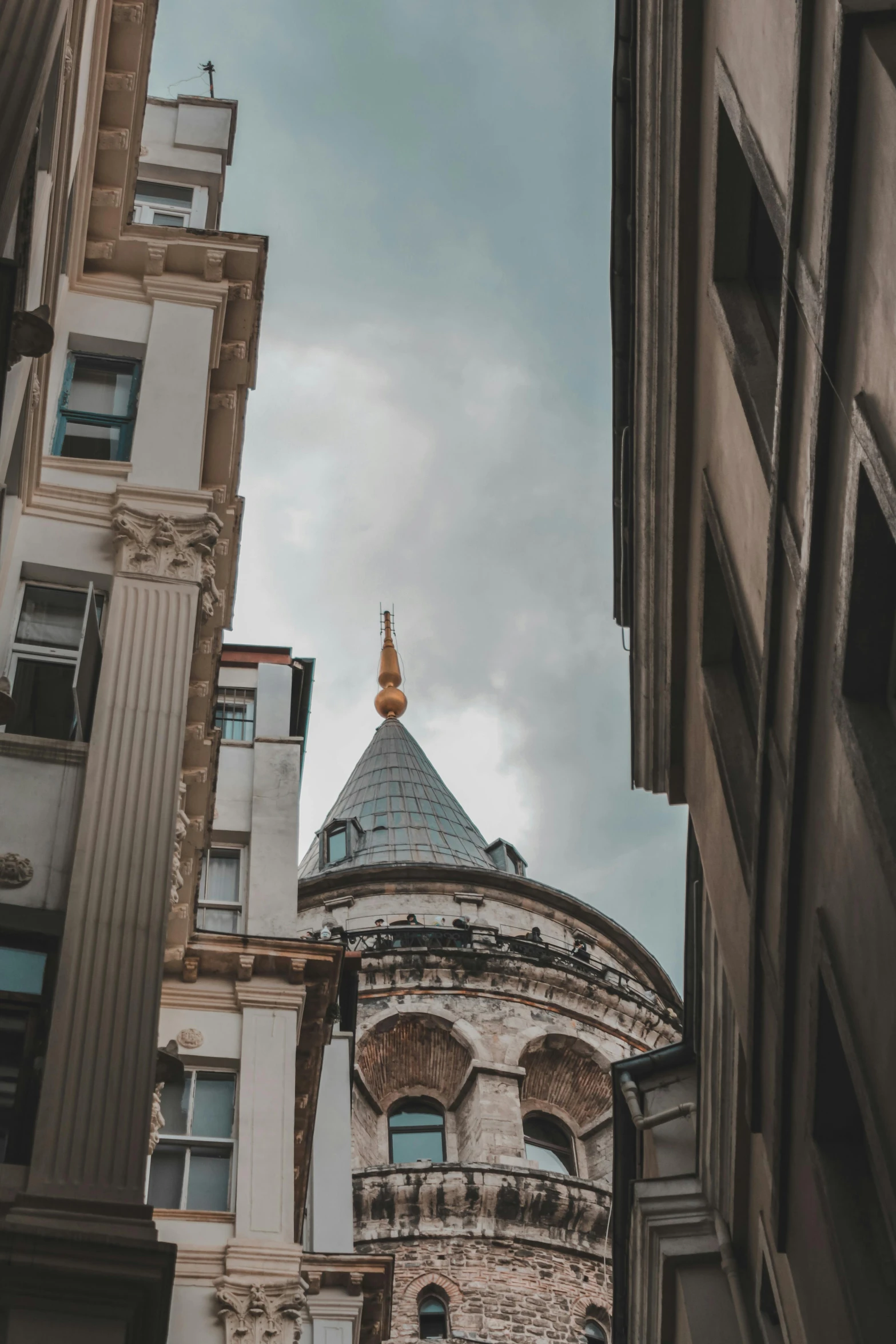 a view from behind an older building with a tall steeple