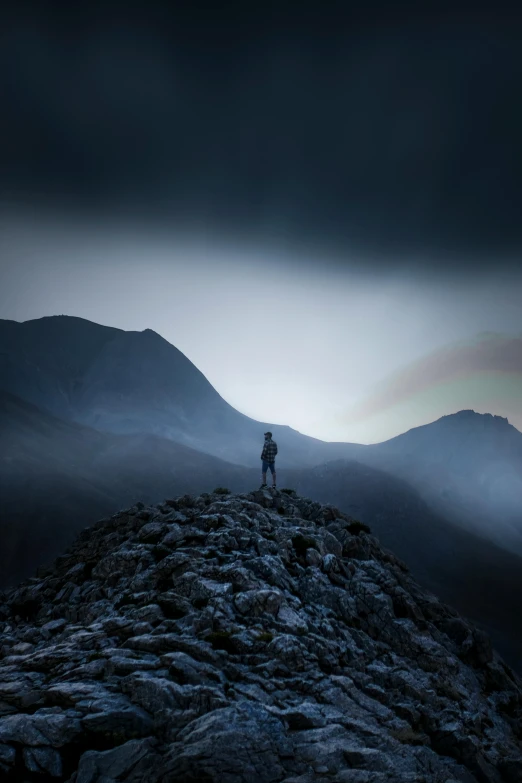 a person is standing on top of the mountain