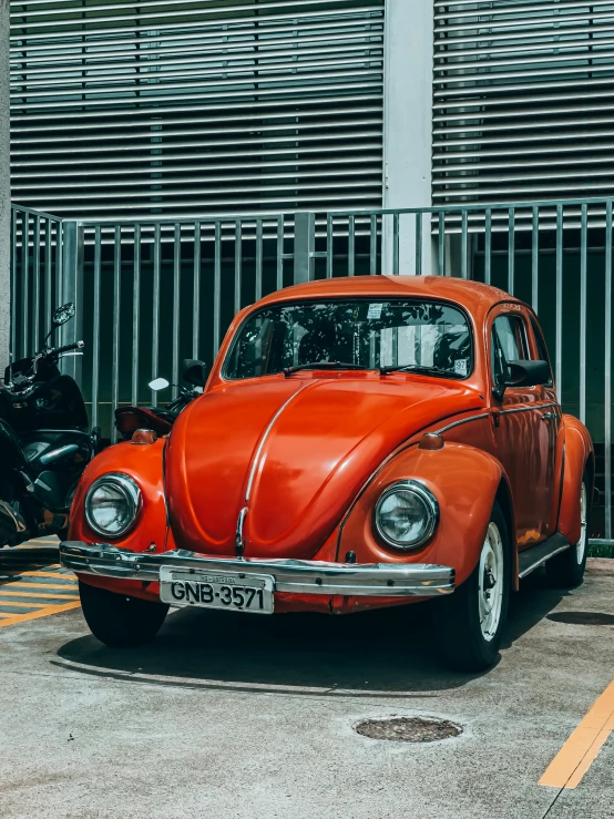 an orange vw bug parked in front of a tall building