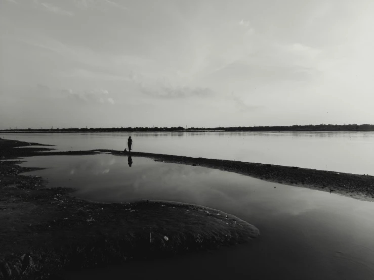 black and white pograph of man standing in water looking back