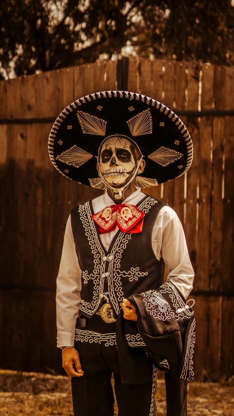 a person wearing a skull face mask with a mexican style costume