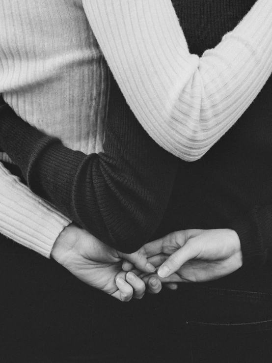 a couple holds hands while posing for a black and white pograph