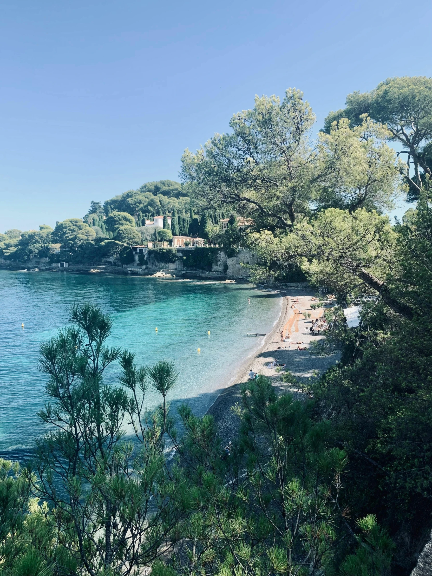 people are lounging out on the beach near a beautiful lake