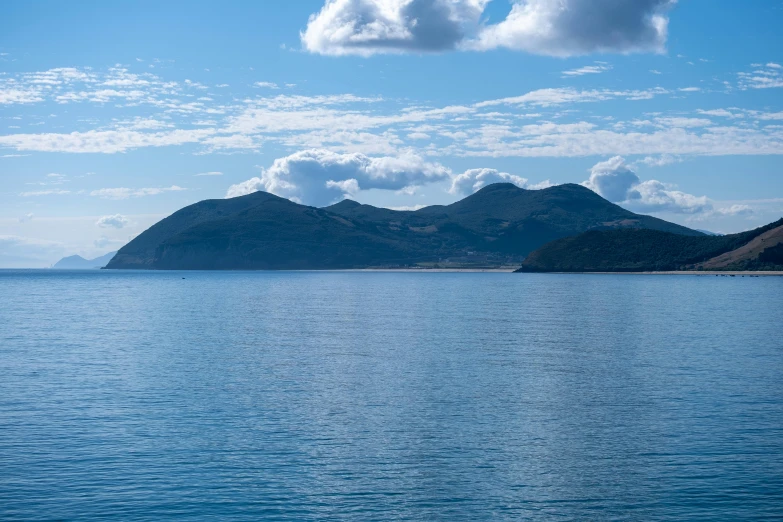 a small boat on the water surrounded by mountains