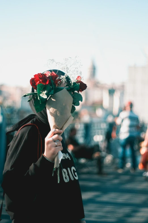 a man holding a bunch of flowers in the street