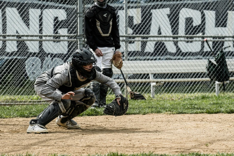 a baseball player crouching down to catch the ball