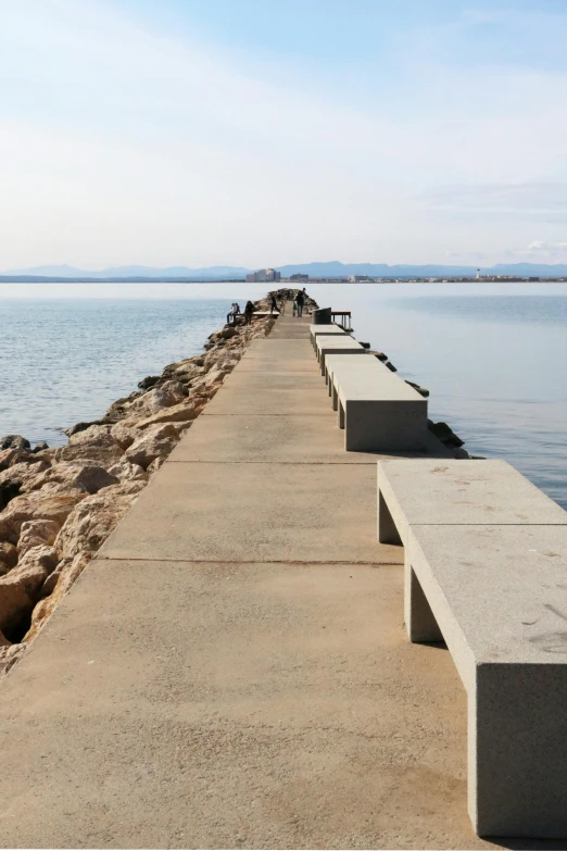 this is the end of a long concrete walkway that stretches over the ocean