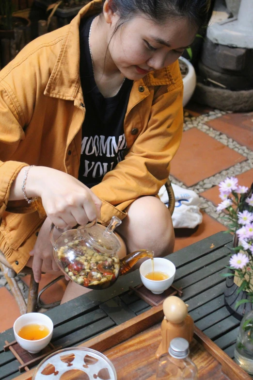 a woman putting food in a bowl, near another woman