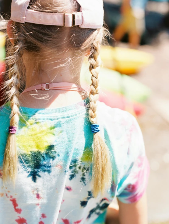 girl with ponytails wearing hat outside in the daytime