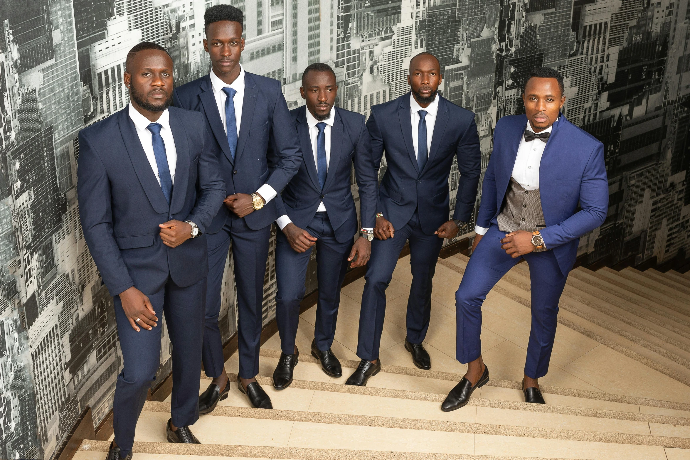 men posing for a picture in suits on stairs