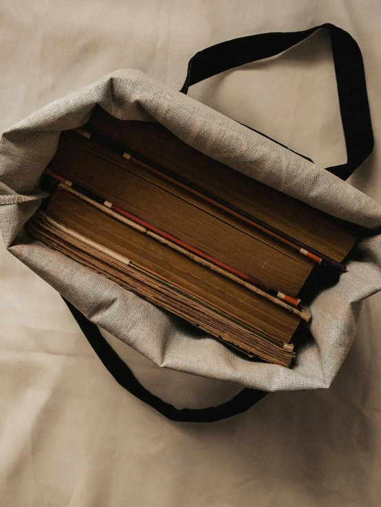 an old bag full of old clothes sitting on a white bed