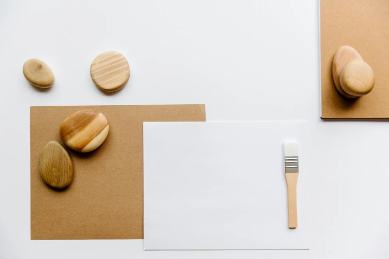 a white paper with two wooden rounds and a small brush