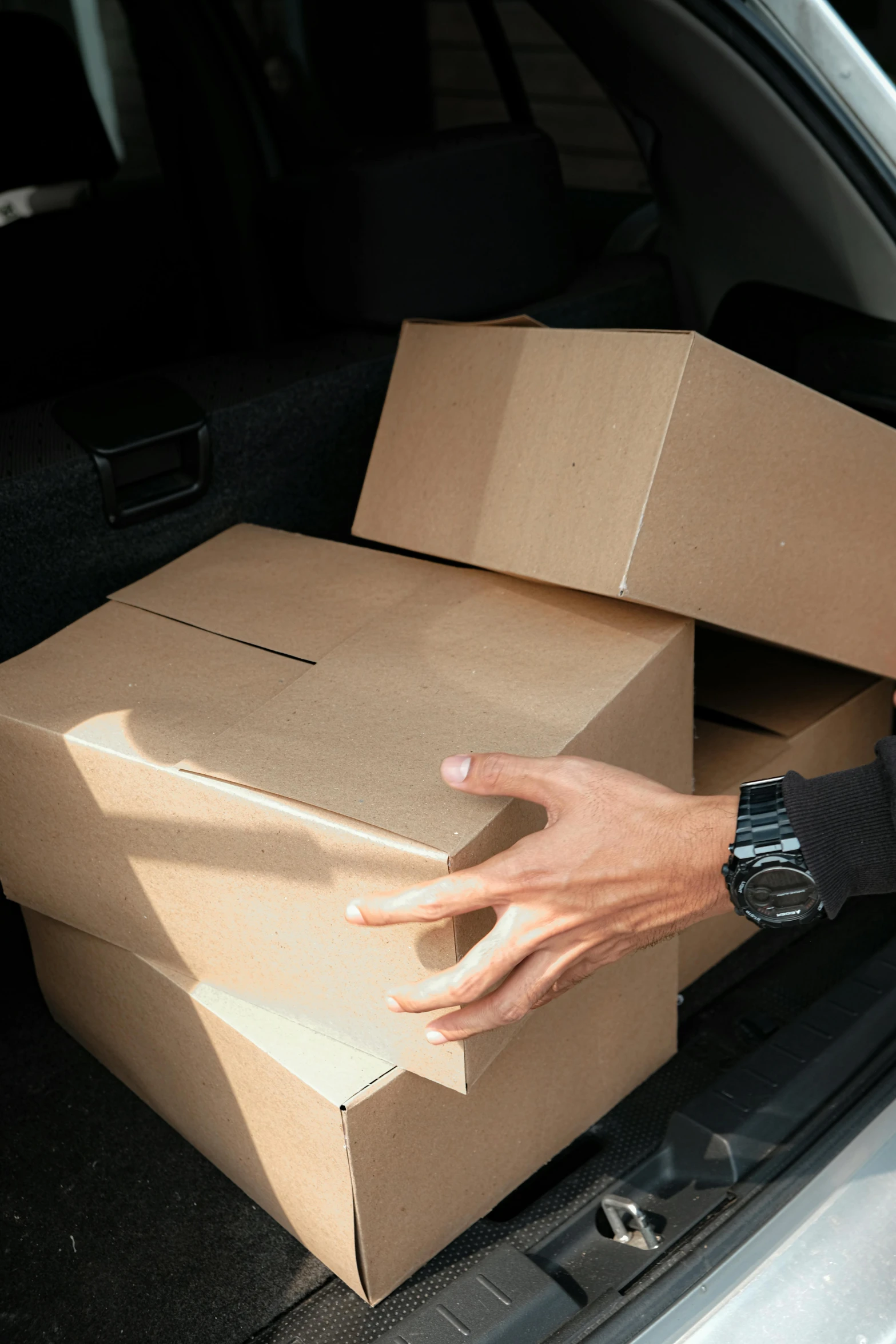 a person is putting boxes into the back of a car