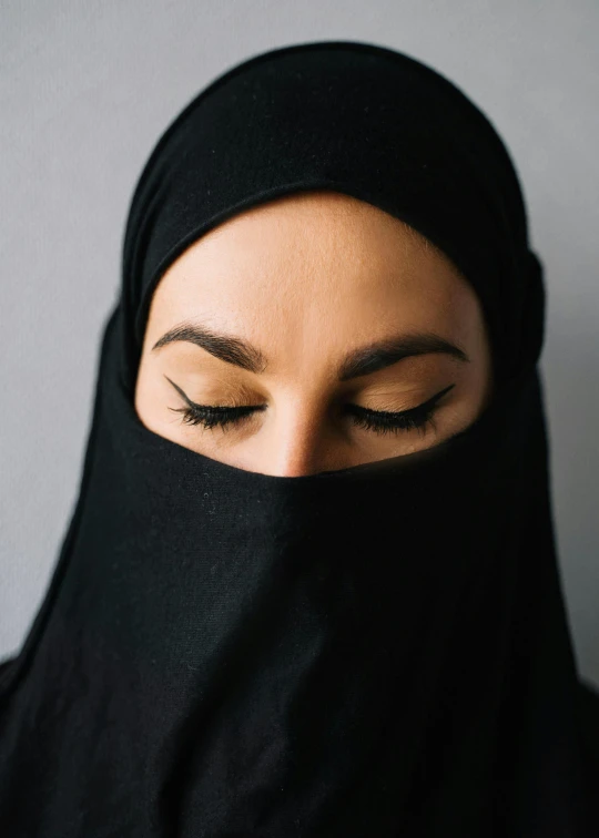 there is a woman with closed eyes wearing a headscarf