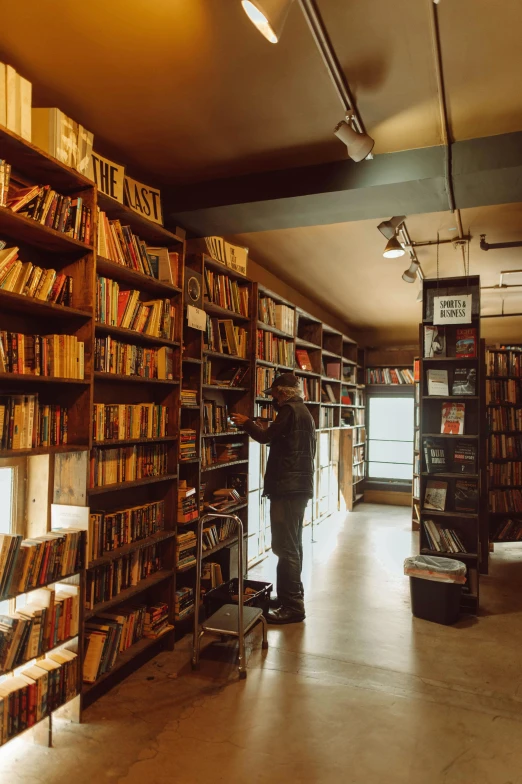 a man reading and looking through the book shelves