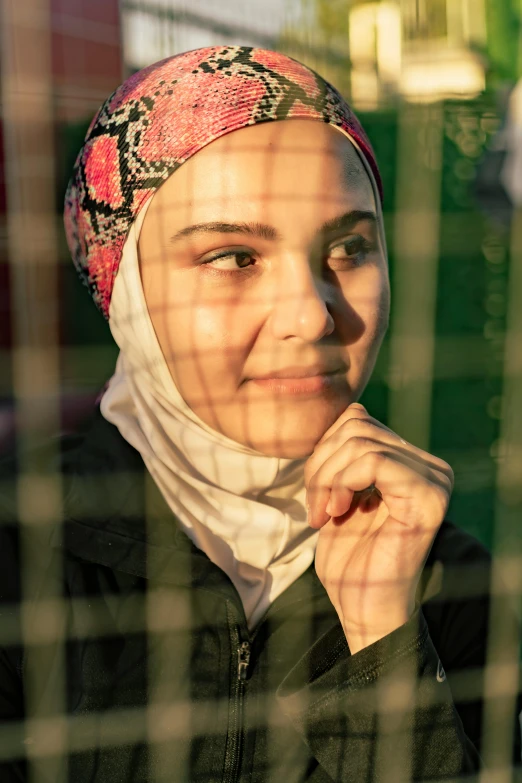 a beautiful young woman wearing a headscarf looking into the distance