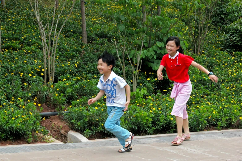 two s running down a path near some wildflowers