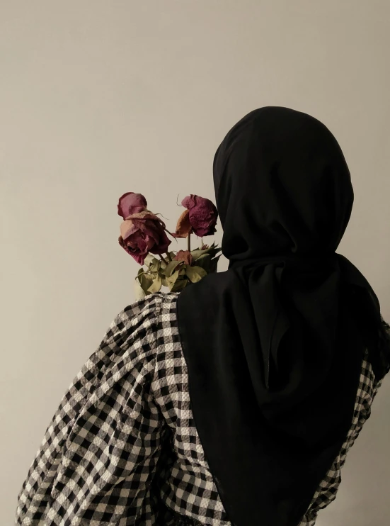 a woman wearing a black and white dress holding flowers