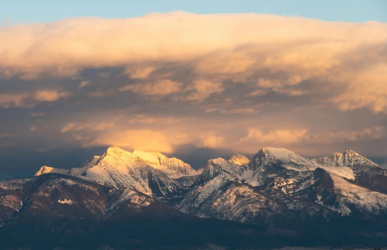 a very tall mountain covered in a cloud filled sky