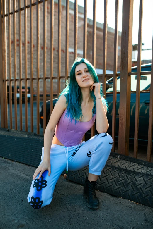 young woman in purple shirt and pants sitting on curb