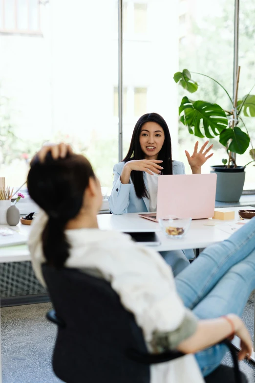 two women are talking to one another at a table