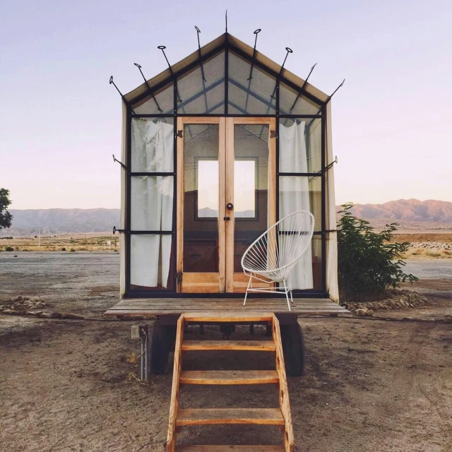 a simple house is situated in the middle of the desert