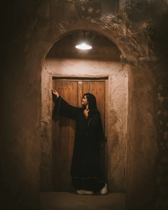 a woman dressed in black in a doorway