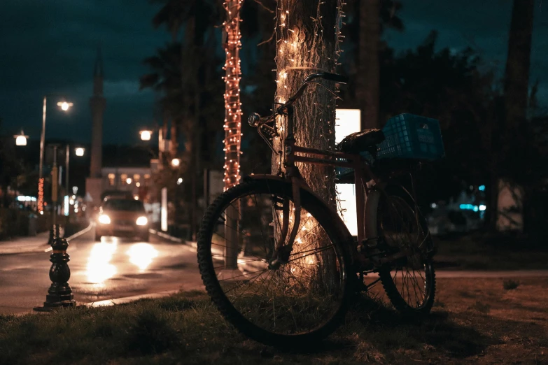 a bike is parked on the curb near a pole and lights