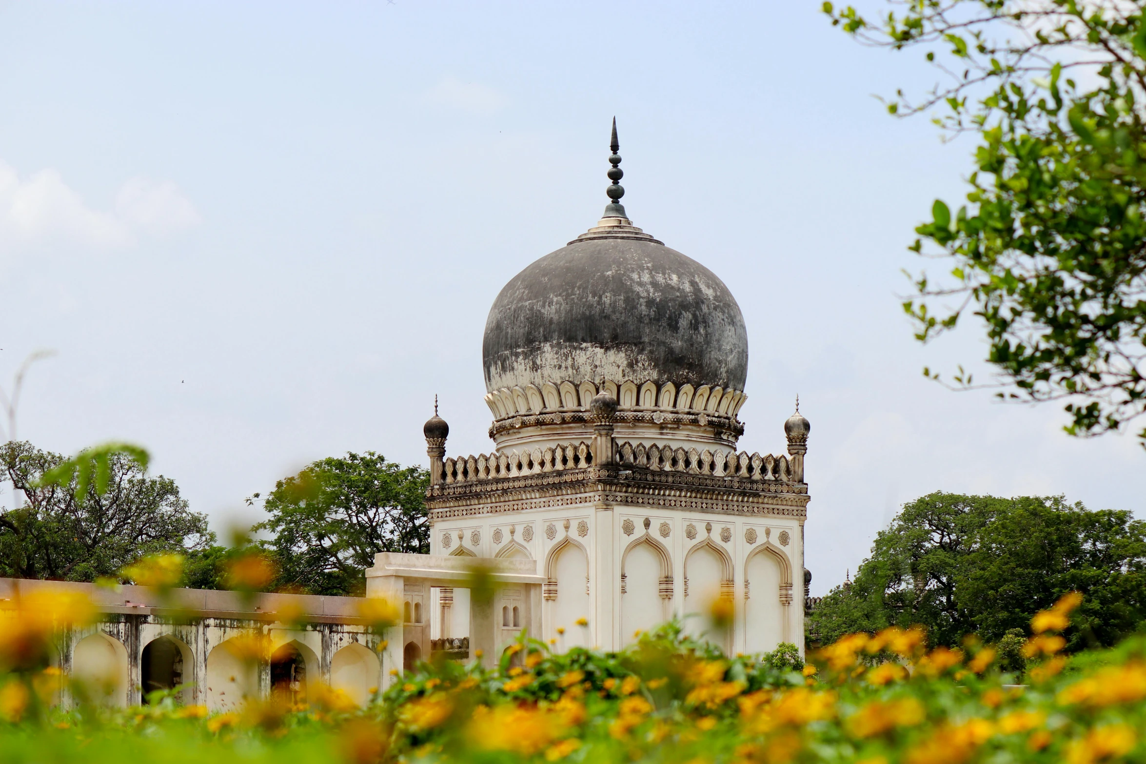 the domed building in front of trees and flowers