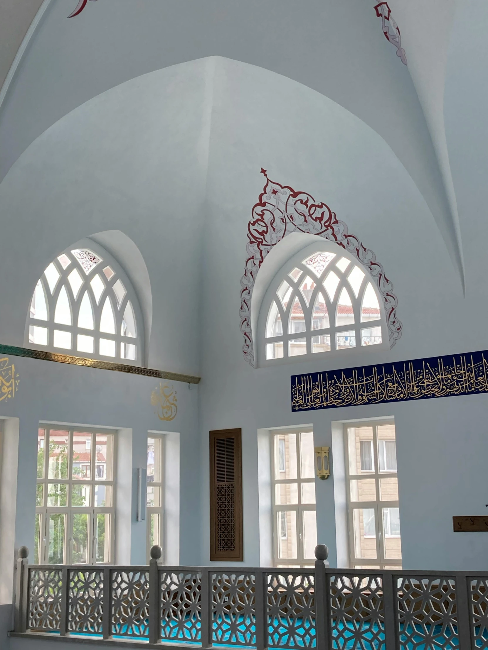 a living room with arched windows and a railing