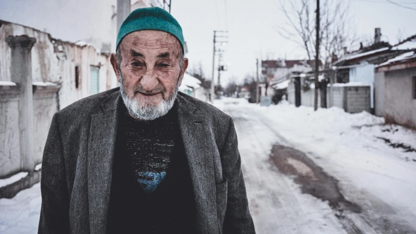 an old man wearing a green hat on his head