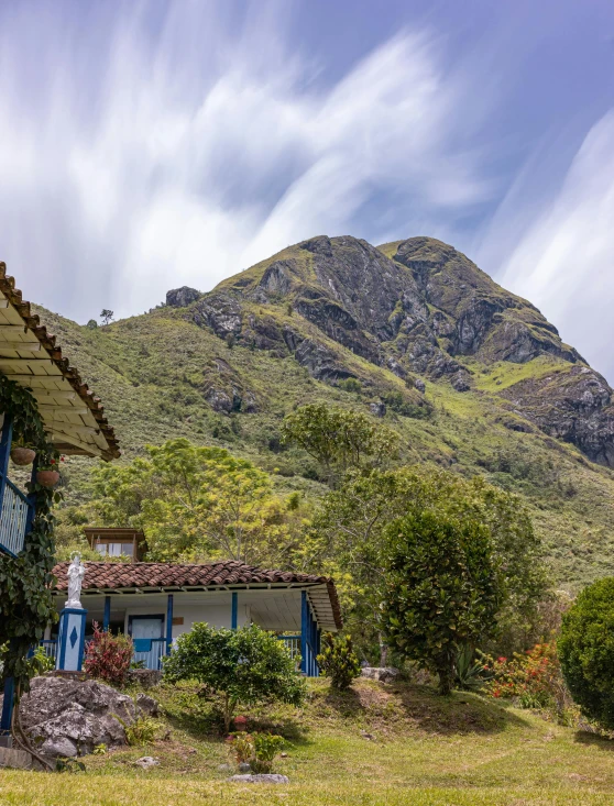 a house on a hillside with a large mountain in the background