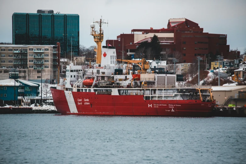 a large red boat sitting next to a city