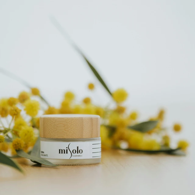 an ojaymy skin polish jar next to a yellow flower