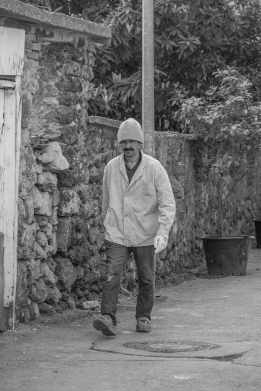 a black and white po of a man walking in a street