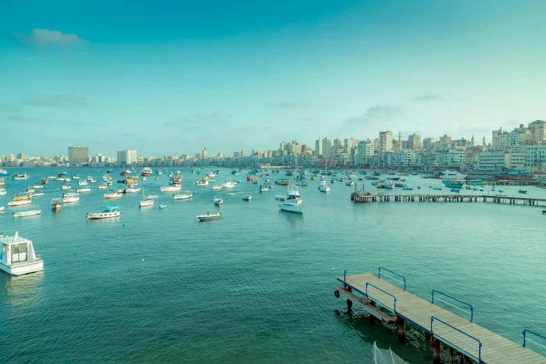 boats floating on the ocean with a city in the background