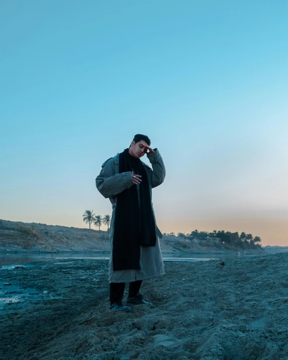 a man stands in the desert on his cell phone