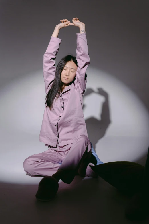 a woman sitting on the ground doing a yoga pose