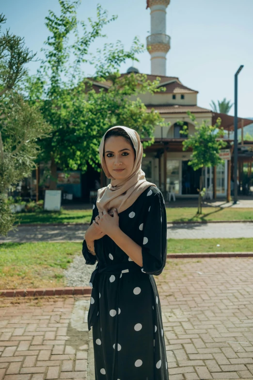 a woman is posing with her hand on her hip