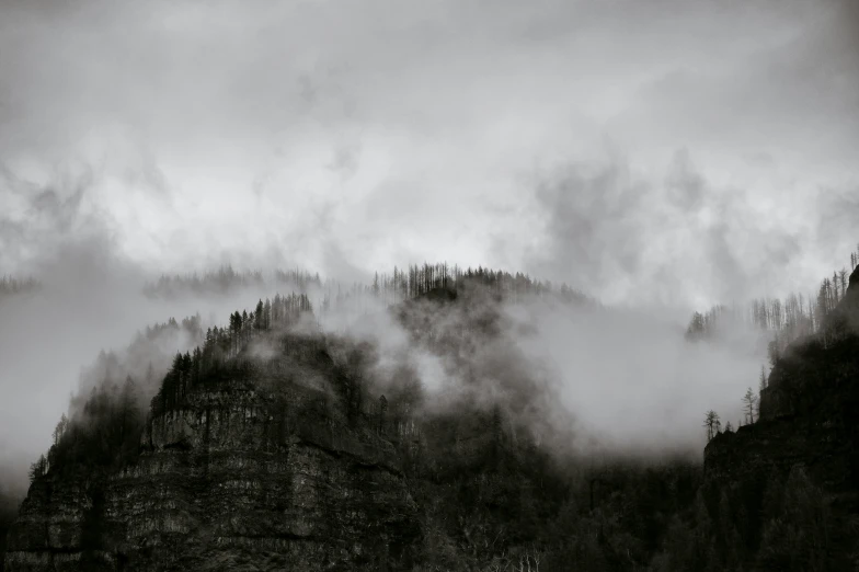 a view of a mountain through a foggy sky