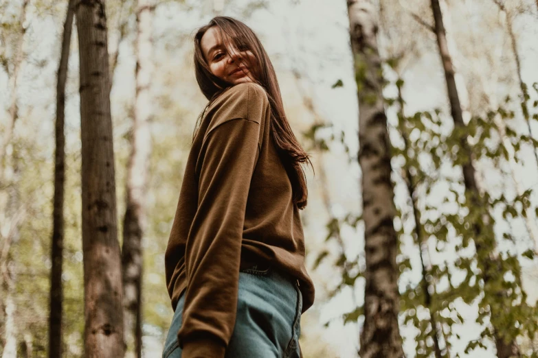 the girl is posing for a picture in the woods