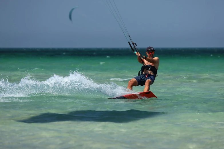 a man para - sailing in the ocean, on a cloudy day