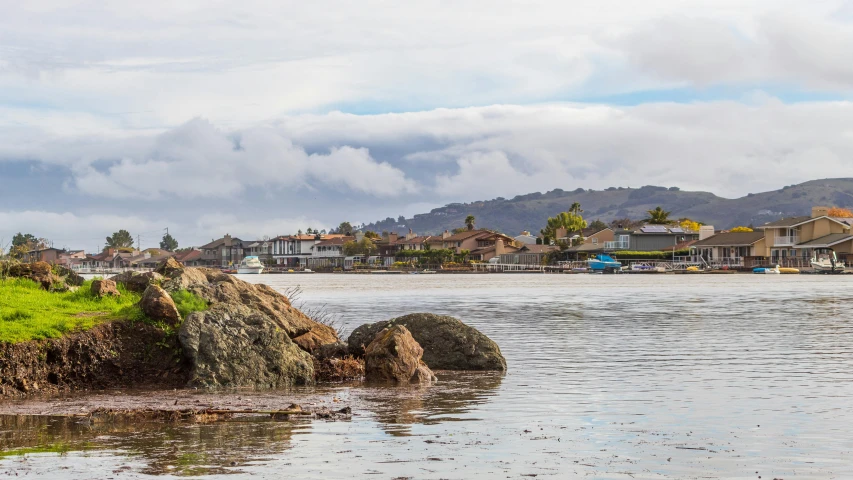 a bunch of houses are sitting on the hill by the water