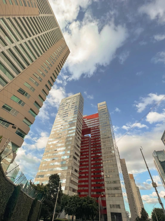 three tall buildings with red and yellow scaffoldings on each side